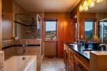 Step into luxury with this stunning bathroom featuring a spacious shower and a relaxing bathtub.