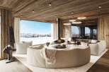 Experience luxury living in this stunning chalet, boasting a cozy fireplace and breathtaking views of a snow-covered landscape.