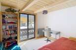 This charming bedroom features a cozy bed with a vibrant red cover, perfect for a relaxing retreat.