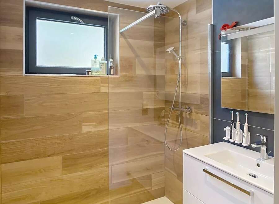 Step into this modern bathroom featuring a sleek shower with a glass enclosure and a stylish vanity.