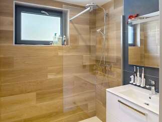 Step into this modern bathroom featuring a sleek shower with a glass enclosure and a stylish vanity.