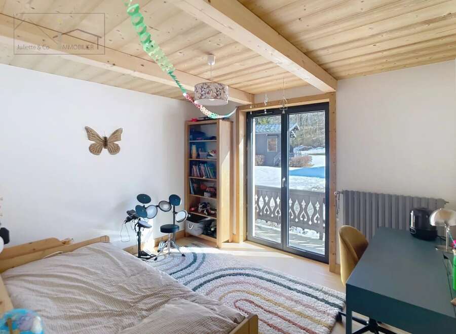 This charming bedroom features a cozy bed, a colorful rug, and a drum set, perfect for relaxation and entertainment.
