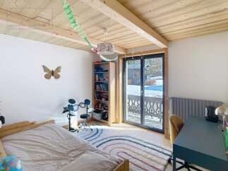 This charming bedroom features a cozy bed, a colorful rug, and a drum set, perfect for relaxation and entertainment.