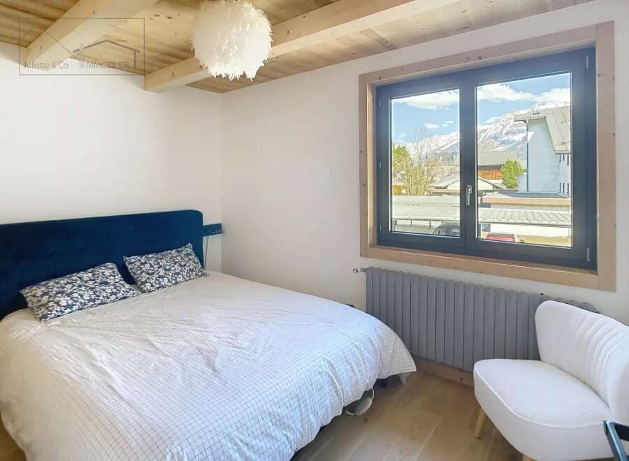 Discover this charming bedroom featuring a cozy bed and a stunning view through the window.