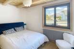 Discover this charming bedroom featuring a cozy bed and a stunning view through the window.