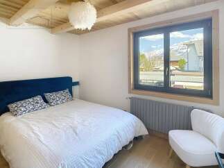 Discover this charming bedroom featuring a cozy bed and a stunning view through the window.