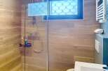 Step into a modern bathroom oasis! This stunning space features a sleek glass shower, complemented by elegant wood-look tile.