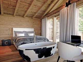 Experience luxury living in this stunning bedroom featuring a unique cowhide bathtub.