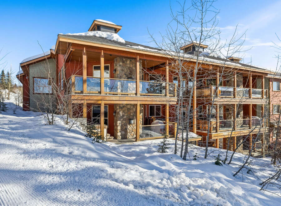 This stunning property boasts a beautiful exterior with wooden accents and stone features, creating a warm and inviting atmosphere.