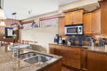 This stunning kitchen boasts beautiful granite countertops and rich wooden cabinetry, creating a warm and inviting atmosphere.