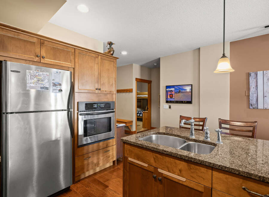 This stunning kitchen boasts beautiful wooden cabinetry and stainless steel appliances, creating a warm and inviting atmosphere.
