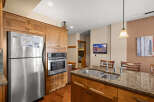This stunning kitchen boasts beautiful wooden cabinetry and stainless steel appliances, creating a warm and inviting atmosphere.