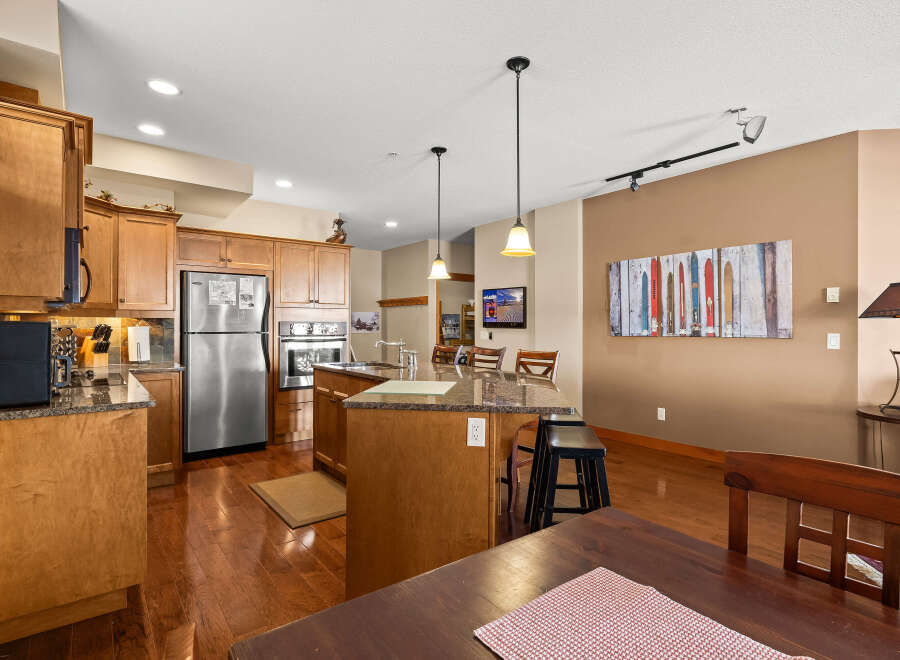 This stunning kitchen boasts beautiful wooden cabinetry and sleek stainless steel appliances, creating a warm and inviting atmosphere.