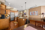 This stunning kitchen boasts beautiful wooden cabinetry and sleek stainless steel appliances, creating a warm and inviting atmosphere.