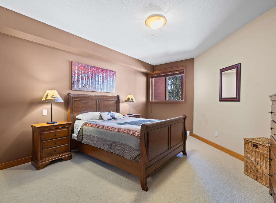 This cozy bedroom features a beautiful wooden bed frame and matching nightstands, creating a warm and inviting atmosphere.