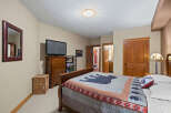 This cozy bedroom features a comfortable bed with a unique bear-themed quilt, perfect for a relaxing retreat.