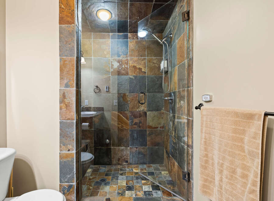 Step into luxury with this stunning bathroom featuring a walk-in shower with beautiful stone tile.
