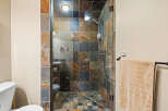 Step into luxury with this stunning bathroom featuring a walk-in shower with beautiful stone tile.