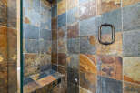 Step into luxury with this stunning shower featuring exquisite stone tile work.