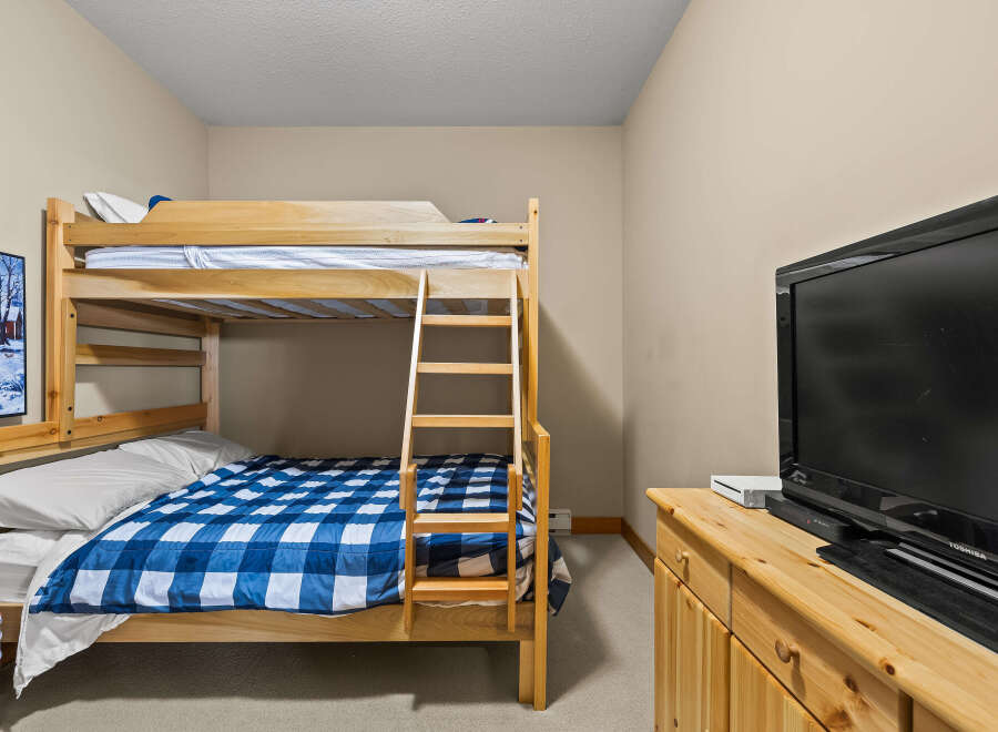 This cozy bedroom features a charming bunk bed, perfect for accommodating guests or family members.