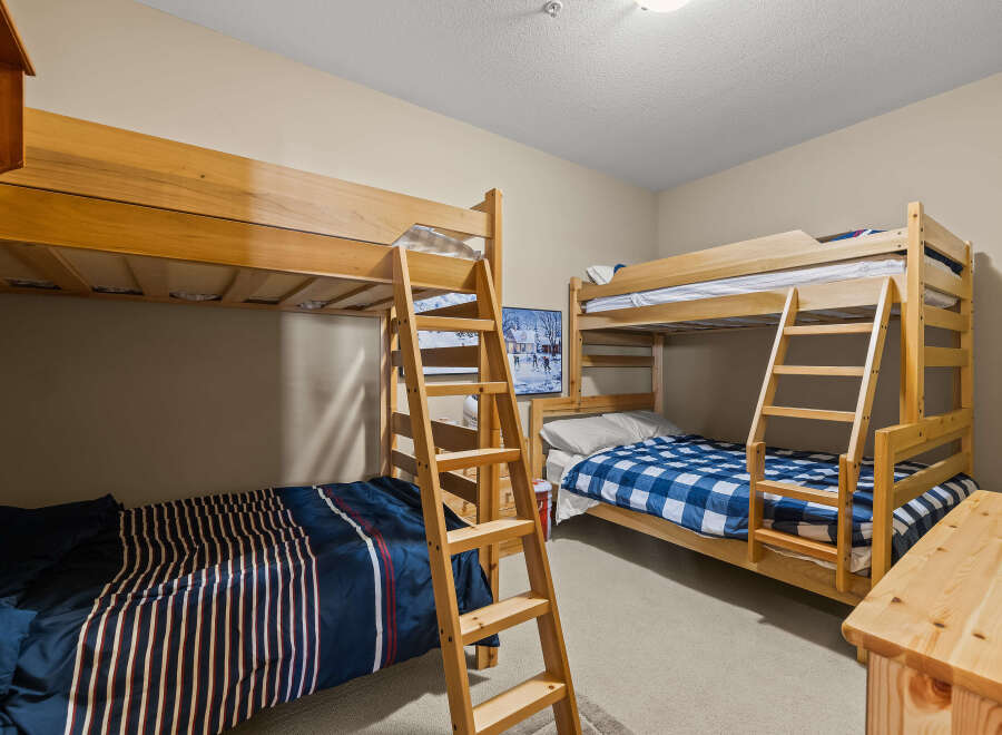 This cozy bedroom features two sets of bunk beds, perfect for accommodating multiple guests or family members.