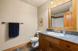 This charming bathroom features a warm, inviting ambiance with its wooden vanity and framed mirror.