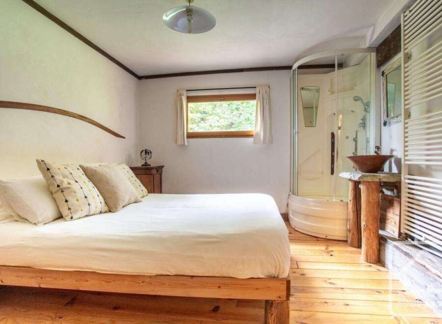 Discover the charm of this cozy bedroom featuring a comfortable bed and a unique wooden frame.