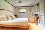 Discover the charm of this cozy bedroom featuring a comfortable bed and a unique wooden frame.