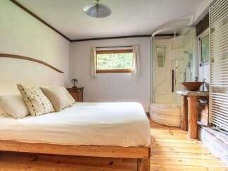 Discover the charm of this cozy bedroom featuring a comfortable bed and a unique wooden frame.