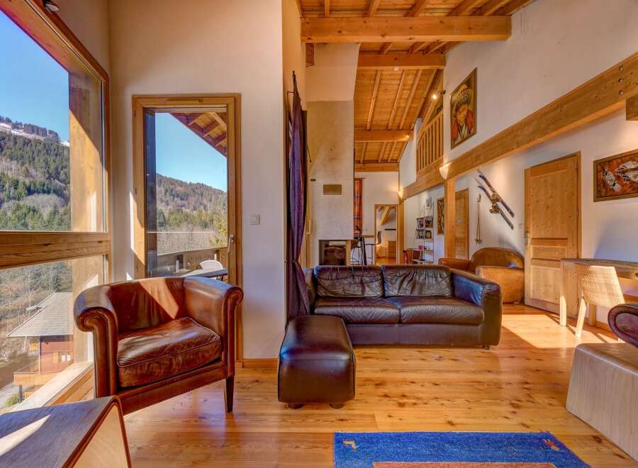 Experience the charm of this stunning property, featuring a cozy living room with a leather sofa and armchair.