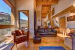 Experience the charm of this stunning property, featuring a cozy living room with a leather sofa and armchair.