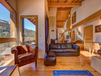 Experience the charm of this stunning property, featuring a cozy living room with a leather sofa and armchair.