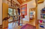 This charming property boasts a cozy dining area with a rustic wooden table and stylish bar stools, perfect for enjoying meals.