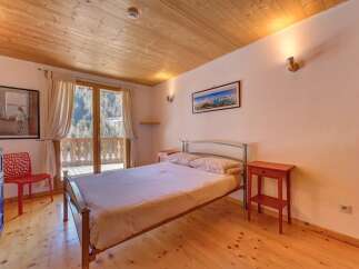 This charming bedroom features a cozy wooden ceiling and flooring, creating a warm and inviting atmosphere.