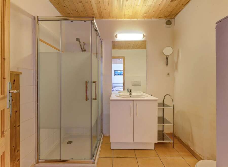 Step into this inviting bathroom, featuring a modern glass shower enclosure and a sleek vanity with a double sink.