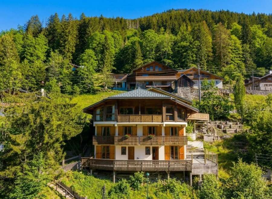 Nestled amidst a lush green forest, this multi-story chalet offers a serene mountain retreat.