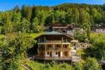 Nestled amidst a lush green forest, this multi-story chalet offers a serene mountain retreat.
