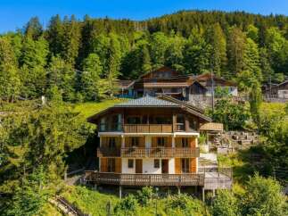 Nestled amidst a lush green forest, this multi-story chalet offers a serene mountain retreat.