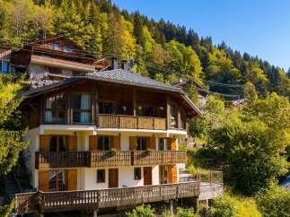 Nestled amidst lush greenery and rolling hills, this stunning multi-level chalet offers breathtaking mountain views and a serene escape.