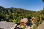 Nestled amidst lush green mountains, this charming wooden chalet offers a serene escape.