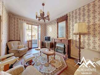 Step into this charming property featuring a cozy living room with a fireplace and elegant chandelier.