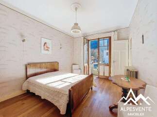 Discover this charming bedroom with a classic wooden bed and a cozy ambiance.