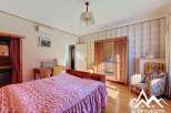 Discover the charm of this inviting bedroom, featuring a cozy bed and elegant wooden furniture.