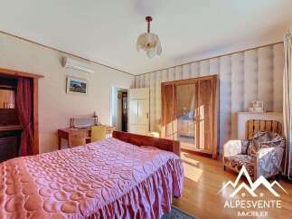Discover the charm of this inviting bedroom, featuring a cozy bed and elegant wooden furniture.