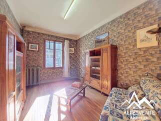 Discover the charm of this property, featuring a cozy living space with wooden floors and a unique brick-style wallpaper.