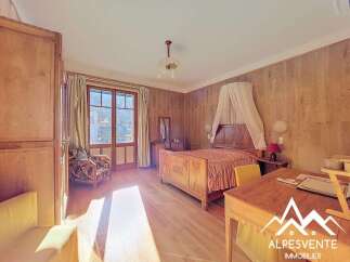 Discover the charm of this inviting bedroom, featuring a classic wooden bed and elegant wooden paneling.