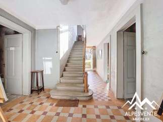 Discover the charm of this property, featuring a grand staircase and classic tiled flooring.