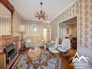Step into this charming property, featuring a cozy living room with a fireplace and elegant chandelier.