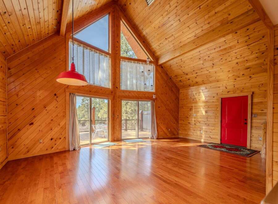 Step into this stunning cabin retreat, featuring a warm and inviting interior with beautiful wood paneling throughout.