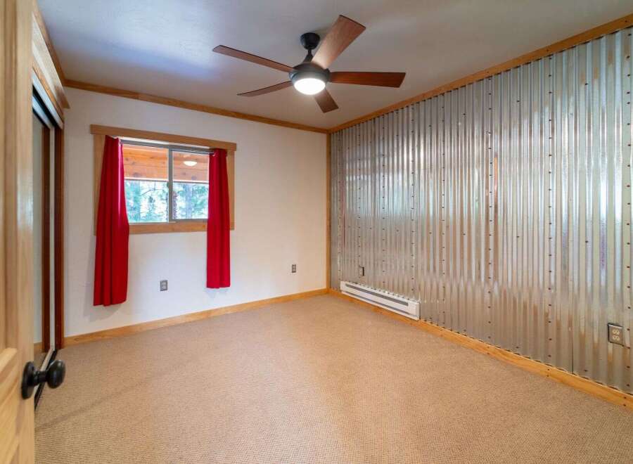 This inviting bedroom features a unique corrugated metal accent wall, adding a touch of industrial charm.